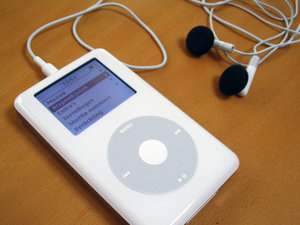 A monochrome fourth-generation iPod with earphones. The iPod has a multilingual interface, seen here using Dutch