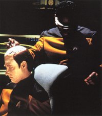 Lt. Cmdr. La Forge assists Data in installing the emotion chip Dr. Soong made for him